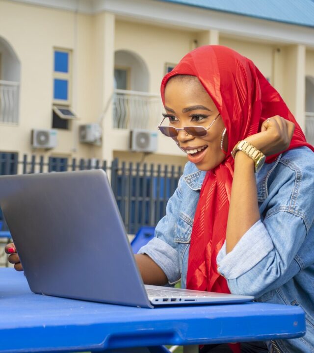 closeup-shot-pretty-young-afro-american-female-looking-excitedly-her-laptop-screen_181624-43269